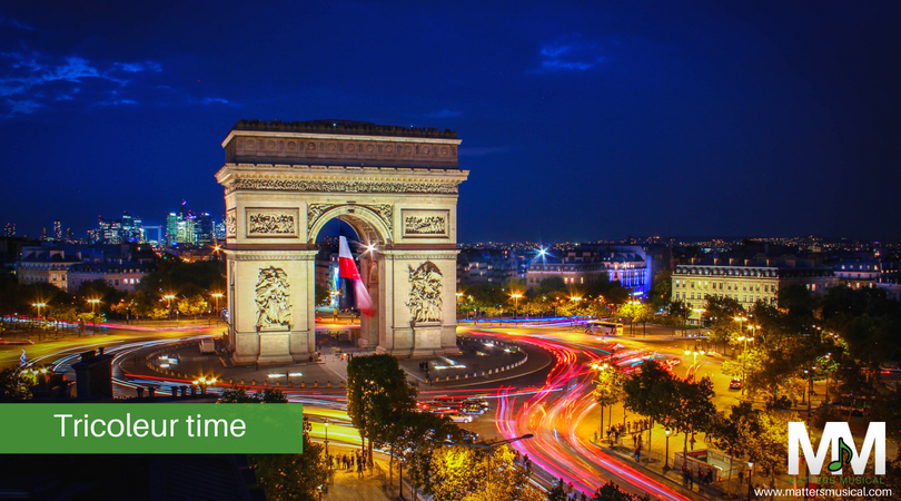 L'arc de Triomphe and French flag by night